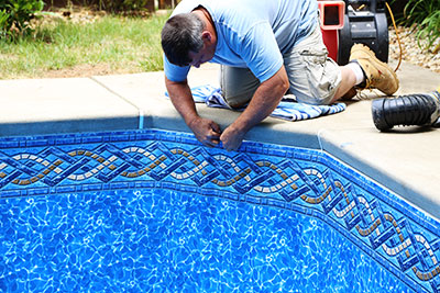 Triad Pool Management LLC technician measuring pool liner